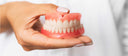 picture of a lady holding her dentures